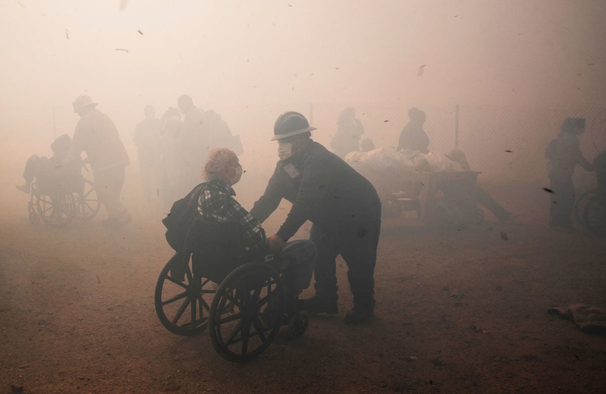 Health care workers evacuate residents from the Riverside Heights Healthcare Center as the Hill Fire grows close