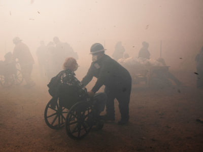 Health care workers evacuate residents from the Riverside Heights Healthcare Center as the Hill Fire grows close