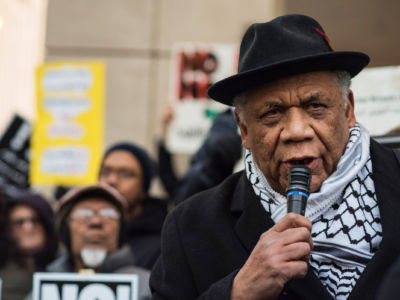 Frank Chapman speaks into a microphone during a rally