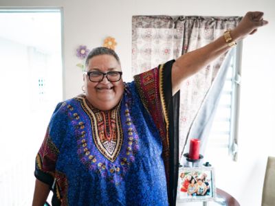 Mirta Colón Pellicier raises her fist in her Section 8 apartment in San Juan, Puerto Rico, in March 2019.