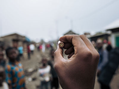 A man shows an AK-47 cartridge collected, according to this man, from the scene of a massacre in the Kilijiwe district of northern Goma, in the eastern Democratic Republic of Congo, on July 24, 2019.