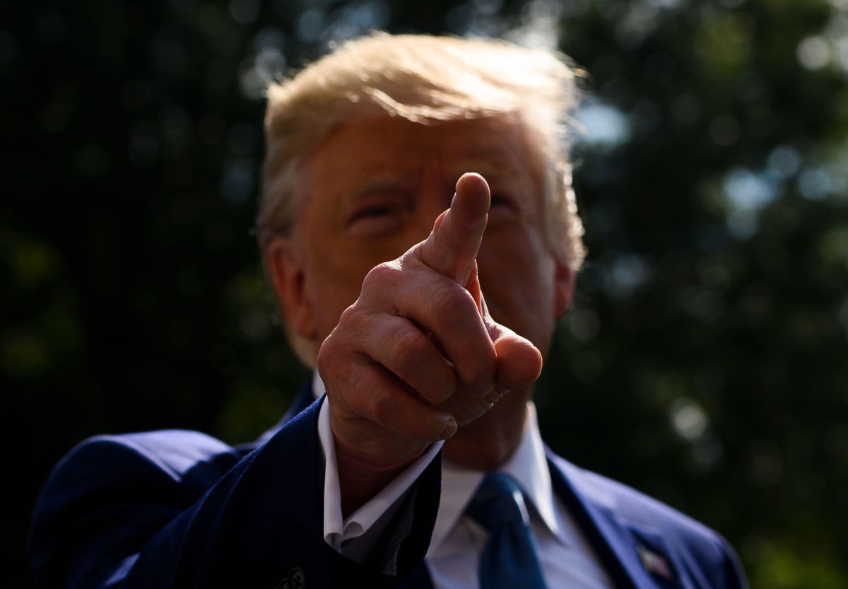 President Trump gestures at reporters as he departs the White House for Walter Reed hospital on the South Lawn on October 4, 2019.