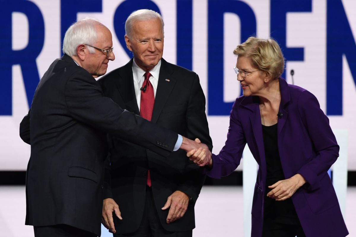 Senators Bernie Sanders and Elizabeth Warren greet each other onstage next to former Vice President Joe Biden