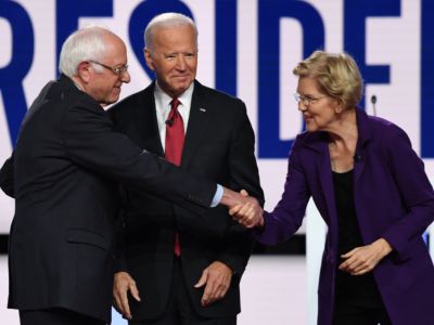 Senators Bernie Sanders and Elizabeth Warren greet each other onstage next to former Vice President Joe Biden