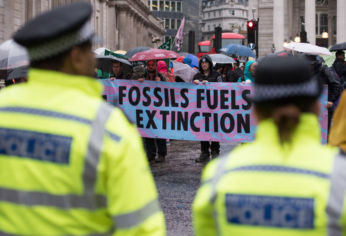 Police look on as Extinction Rebellion protesters block roads outside the Bank of England