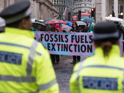 Police look on as Extinction Rebellion protesters block roads outside the Bank of England