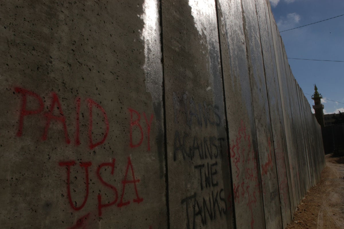 "Paid by USA," is sprayed on the concrete separation wall between the Palestinian city of Abu Dis and Israel, November 22, 2004.