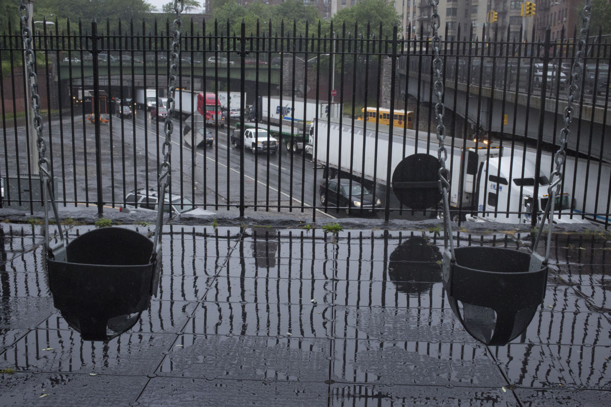 Trucks and cars drive past a children's playground on the Cross Bronx Expressway on May 25, 2017 in the Bronx, New York. The highway is one of the busiest in the nation, and the neighborhoods above it have very high levels of asthma in their communities.