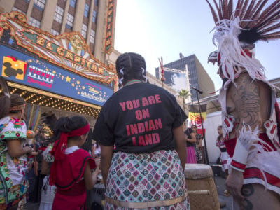 Dancers from Anahuacalmecac International University Preparatory of North America school for indigenous students pray before dancing on Hollywood Boulevard near the El Capitan Theatre during an event celebrating Indigenous Peoples' Day on October 8, 2017, in Los Angeles, California.