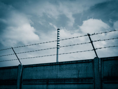 A barbed wire fence against a gray sky