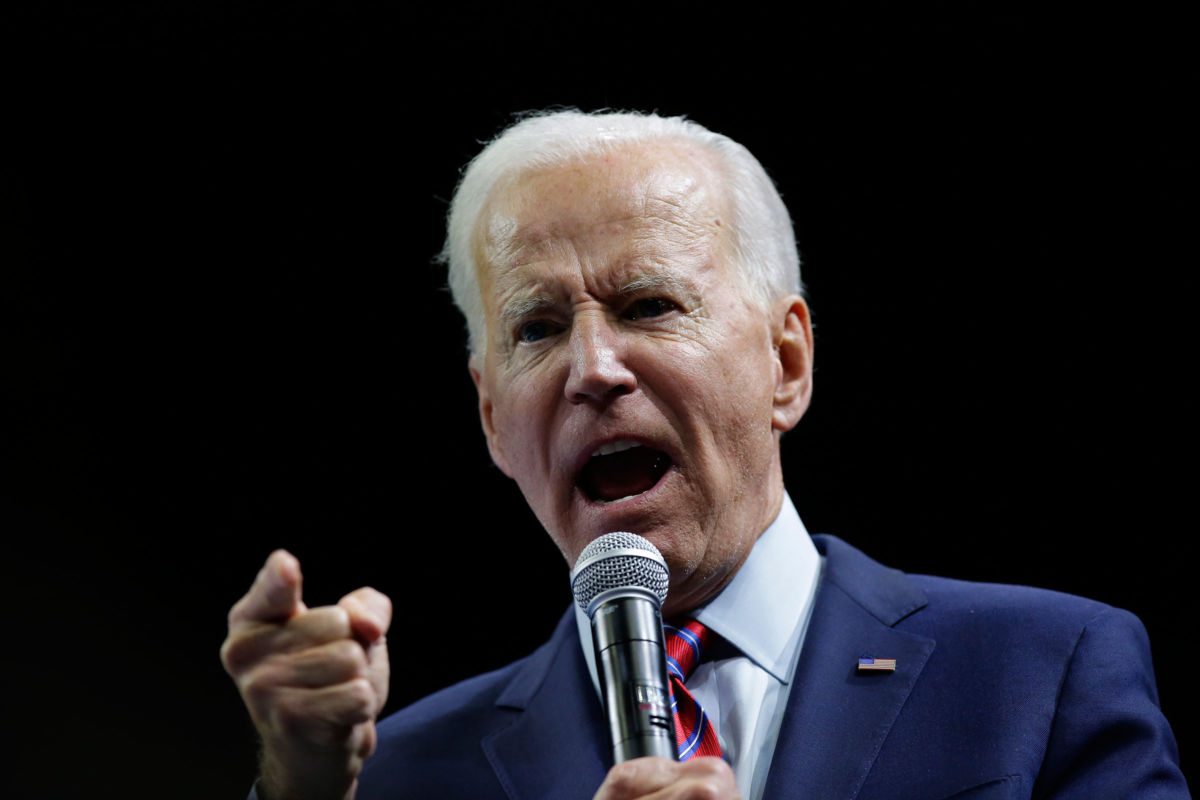 Joe Biden points while speaking into a microphone