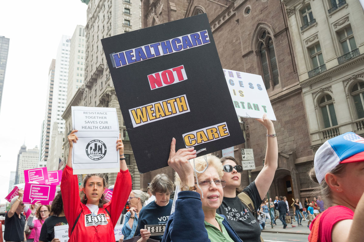 Protesters hold signs opposing the repeal and replacement of the Affordable Care Act on July 29, 2017, in New York City.