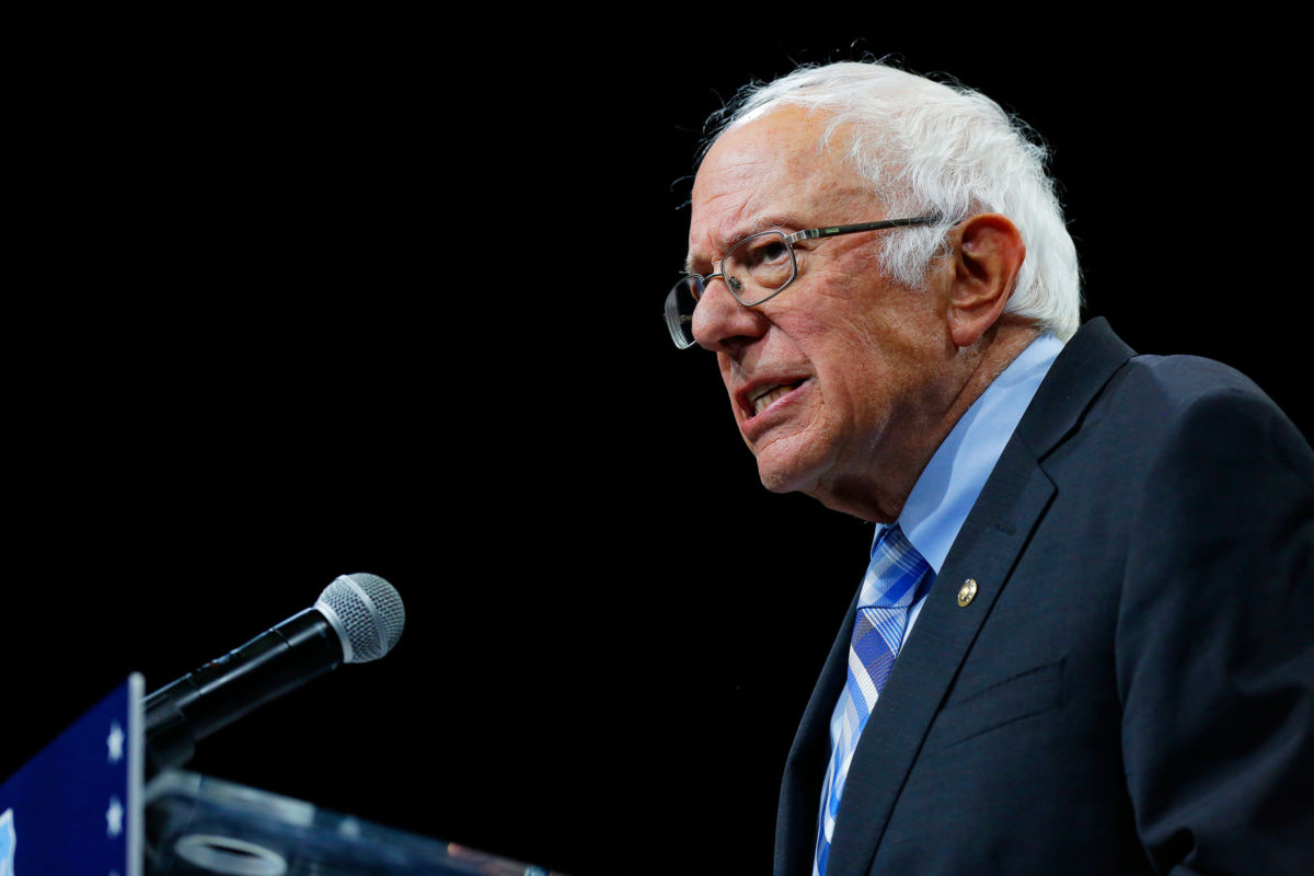 Bernie Sanders speaks into a microphone at podium