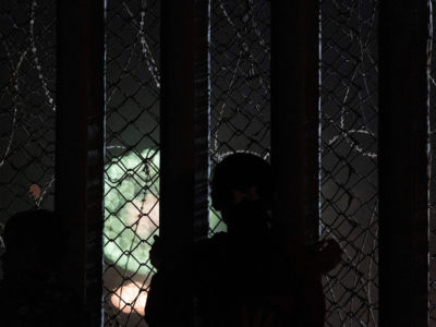 A girl looks through the U.S.-Mexico border fence from the Mexican side to watch Fourth of July fireworks being shot on the San Diego Bay, July 4, 2019.