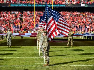 Members of the Armed Forces hold flags on the field during the national anthem ceremony prior to a game at Arrowhead Stadium on November 11, 2018, in Kansas City, Missouri.