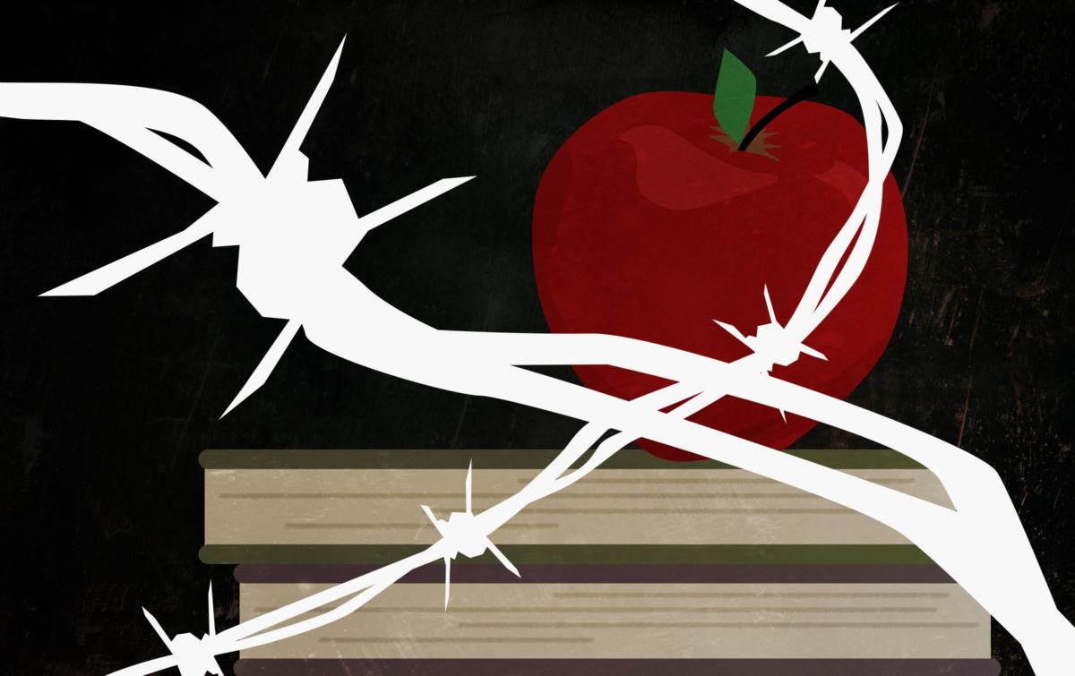 Apple, books and blackboard behind barbed wire