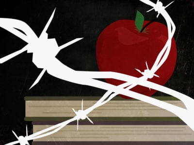 Apple, books and blackboard behind barbed wire