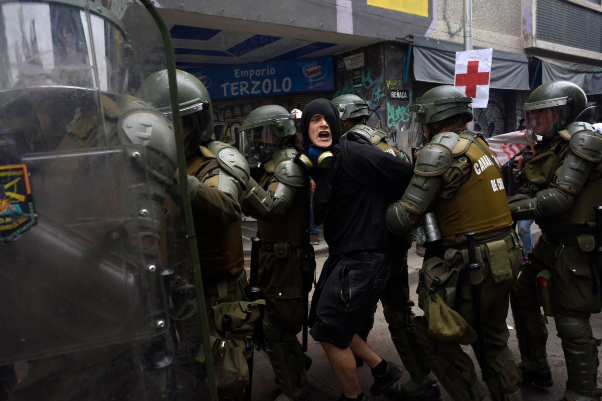 Riot police officers arrest a demonstrator during a protest on November 8, 2019, in Santiago, Chile.