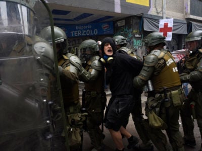 Riot police officers arrest a demonstrator during a protest on November 8, 2019, in Santiago, Chile.