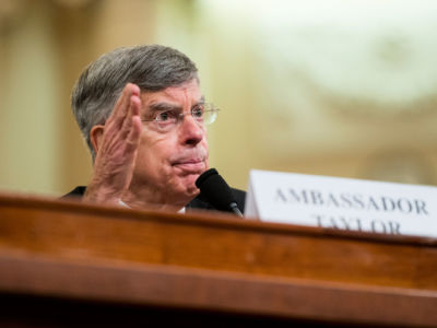 Bill Taylor speaks into a microphone at a hearing