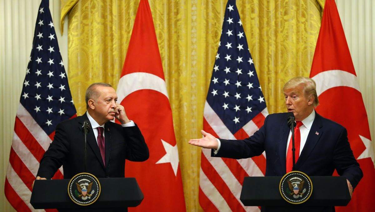 Donald Trump gestures at Tayyip Erdogan as they both stand at podiums