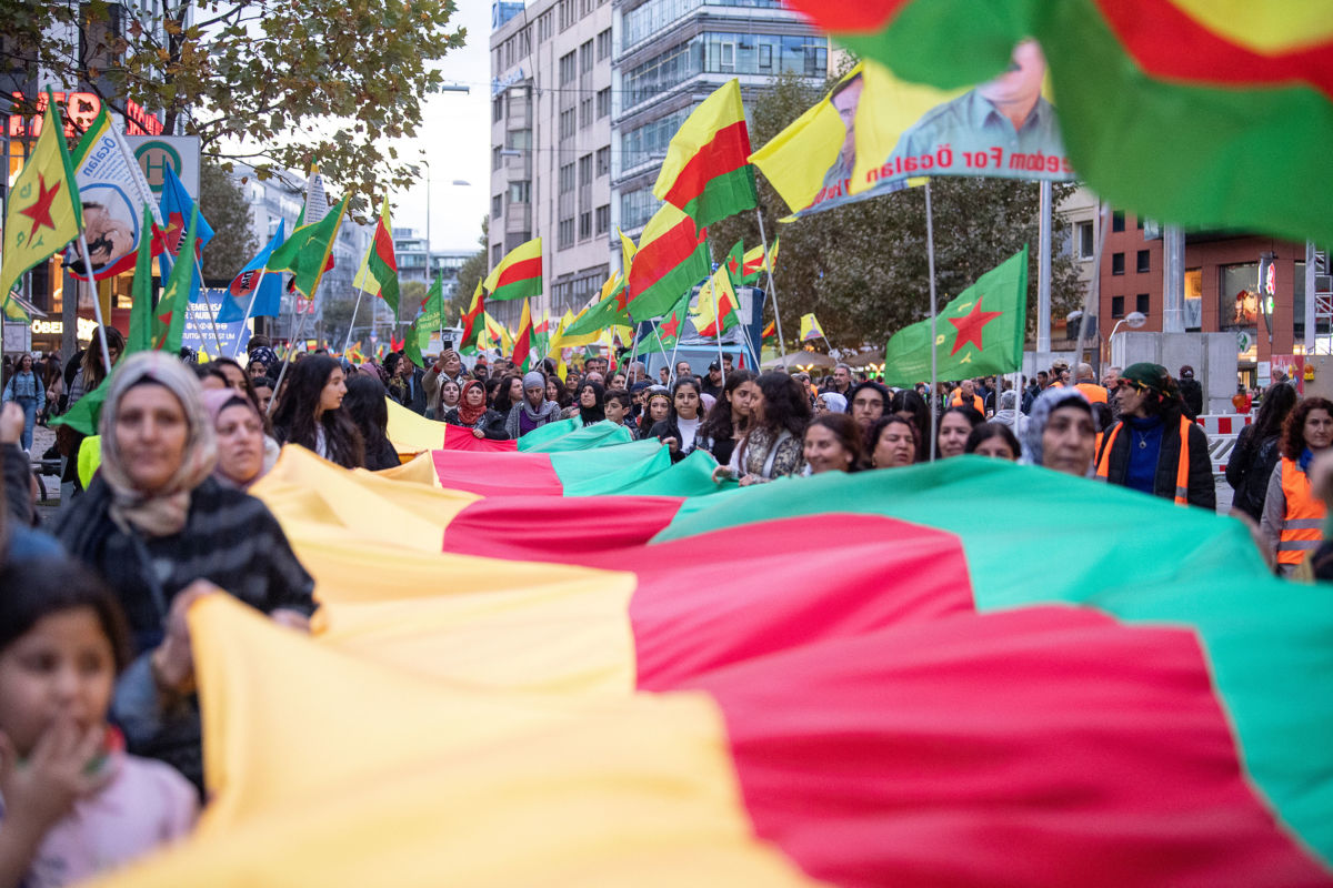 Participants in a demonstration against the Turkish army's invasion of Syria carry a long cloth ribbon with the colors of the Kurdish flag in Stuttgart, November 2, 2019.