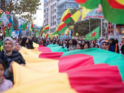 Participants in a demonstration against the Turkish army's invasion of Syria carry a long cloth ribbon with the colors of the Kurdish flag in Stuttgart, November 2, 2019.
