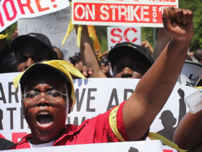 Fast food workers and activists demonstrate outside the McDonald's corporate campus on May 21, 2014, in Oak Brook, Illinois.