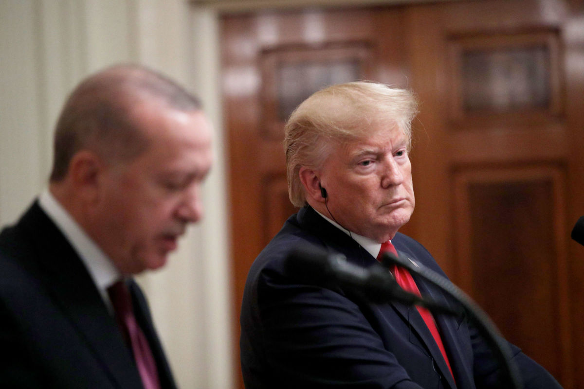 Donald Trump looks downward while standing at a podium