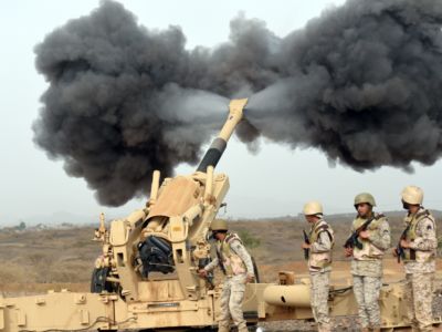 soldiers load artillery into a missie launcher