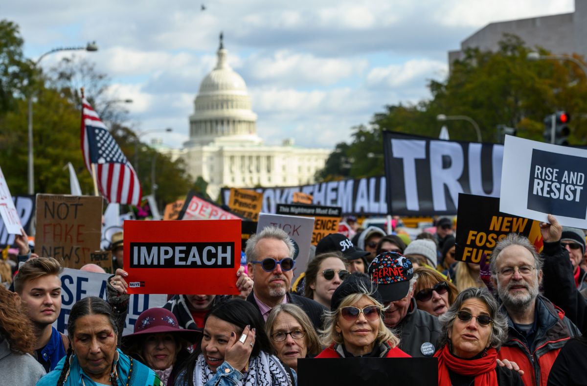 A crowd of protesters march in the street demanding the removal of president Donald Trump from office