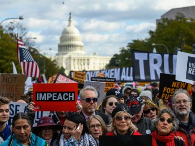 A crowd of protesters march in the street demanding the removal of president Donald Trump from office