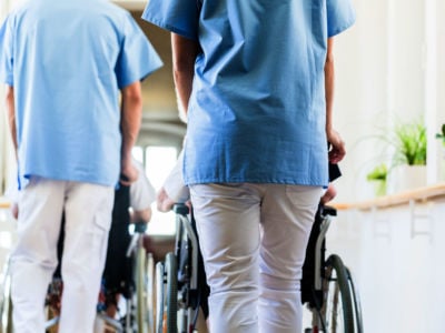 Staff at nursing home pushing wheelchairs