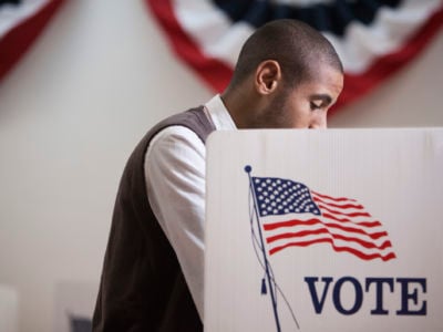 A voter stands at a booth