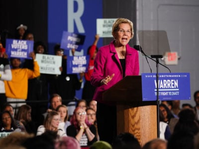 Elizabeth Warren speaks into a microphone at a campaign rally