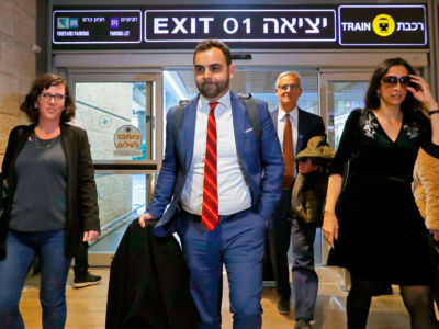 Omar Shakir walks through an airport