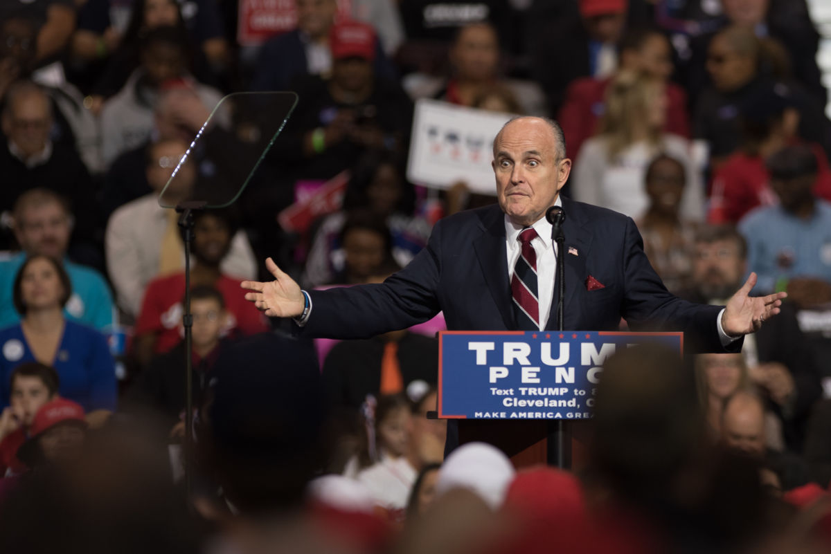 Rudy Giuliani speaks at a podium during a Trump rally