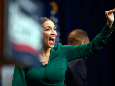 Rep. Alexandria Ocasio-Cortez speaks into a microphone at a rally