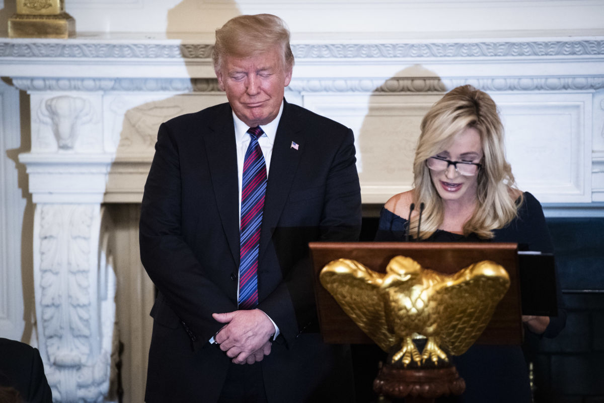 Donald Trump listens as Pastor Paula White leads a prayer at a dinner celebrating Evangelical leadership in the State Dining Room of the White House on Monday, August 27, 2018, in Washington, D.C.