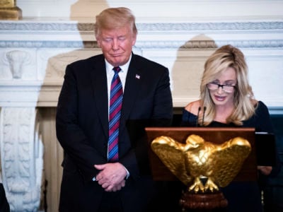 Donald Trump listens as Pastor Paula White leads a prayer at a dinner celebrating Evangelical leadership in the State Dining Room of the White House on Monday, August 27, 2018, in Washington, D.C.