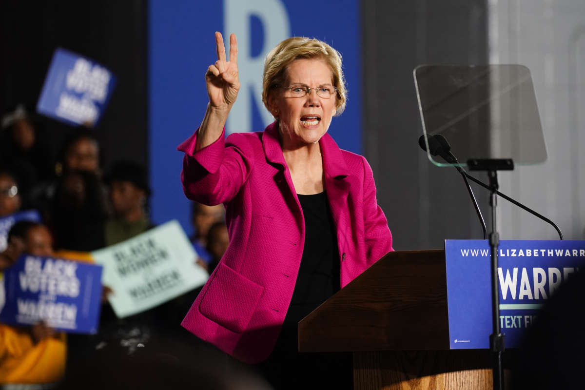 Democratic presidential candidate Sen. Elizabeth Warren (D-MA), holds up two fingers to represent her two-cent wealth tax while speaking at a campaign event at Clark Atlanta University on November 21, 2019, in Atlanta, Georgia.