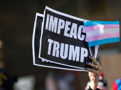 Protesters in support of gay and transgender rights outside on 5th Avenue with signs that say "IMPEACH TRUMP" with a Transgender Pride flag after the 45th President Donald J. Trump gave his opening ceremony of the New York City 100th annual Veterans Day Parade and wreath-lay in New York City on November 11, 2019.