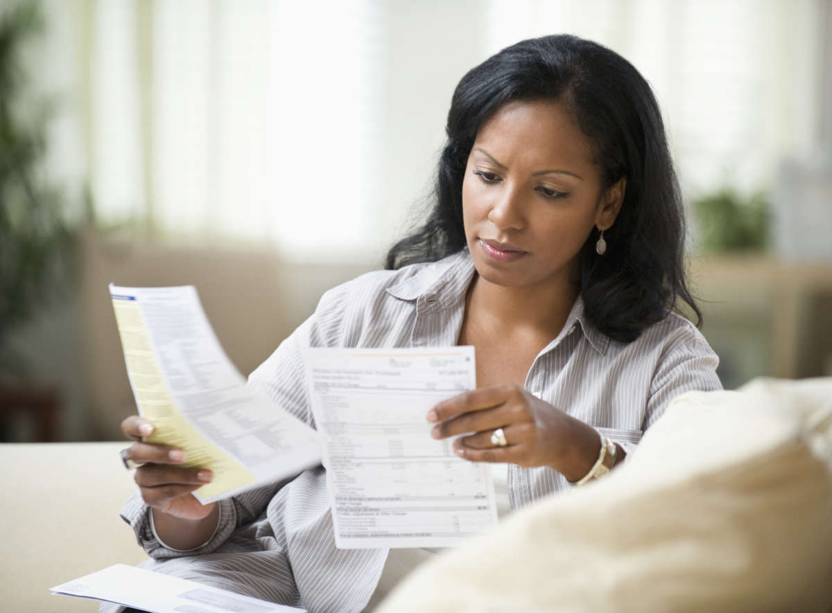 A woman looks at bills in her hands