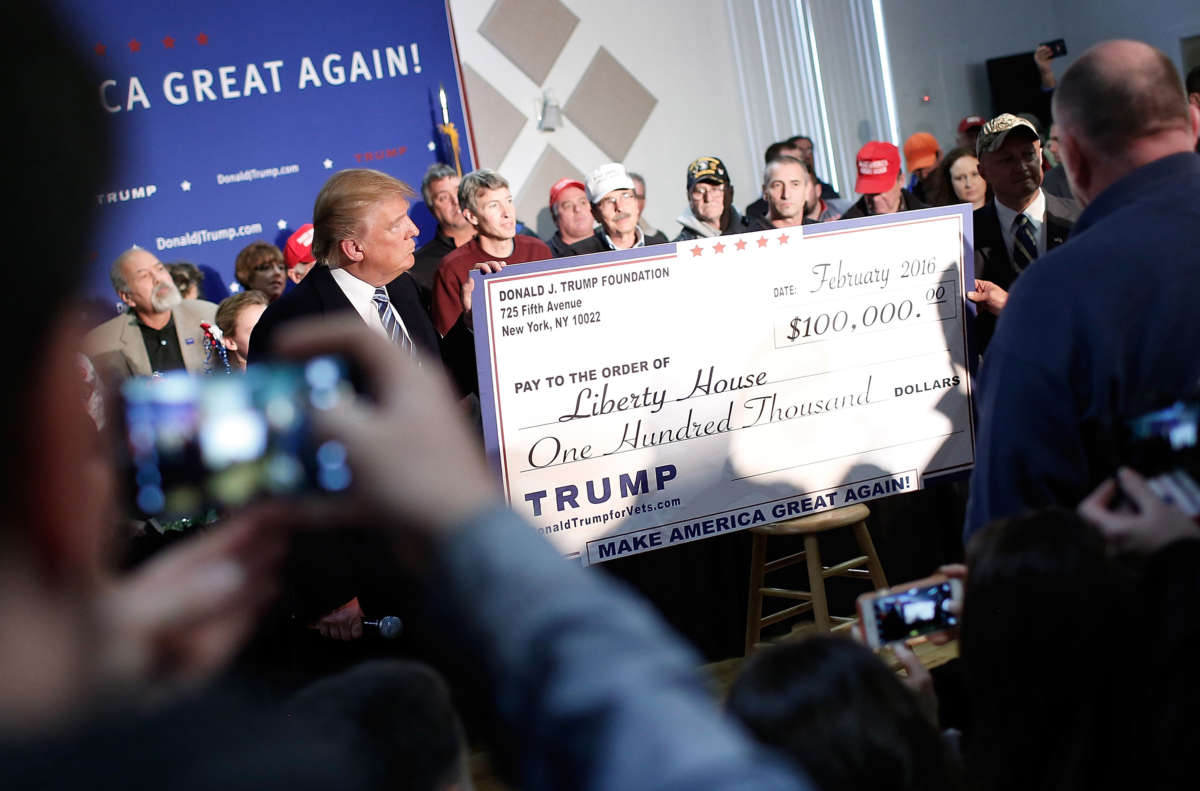 Then-candidate Donald Trump presents a check for $100,000 to the Liberty House during a town hall at the Lions Club February 8, 2016, in Londonderry, New Hampshire.