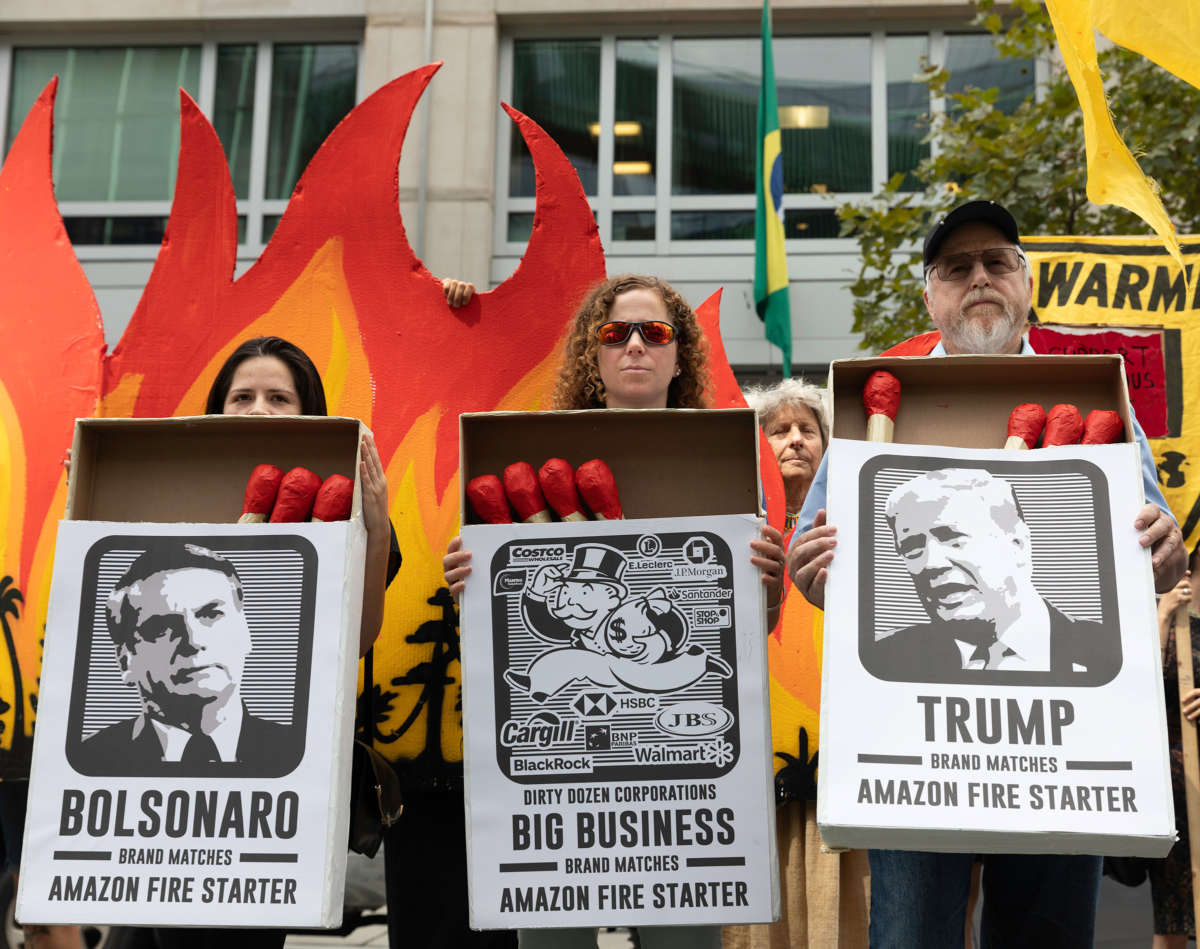 Activists hold large matchboxes with photos of donald trump and jair bolsonaro