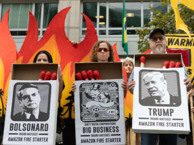 Activists hold large matchboxes with photos of donald trump and jair bolsonaro