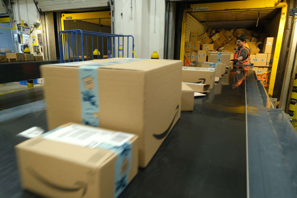 A worker loads a truck with packages at an Amazon packaging center on November 28, 2019, in Brieselang, Germany.