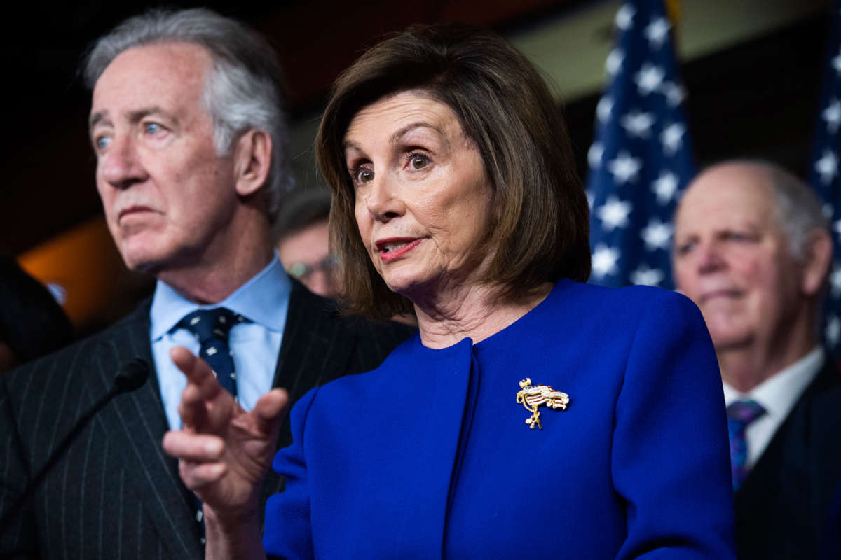 Nancy Pelosi stands alongside other house democrats behind a podium