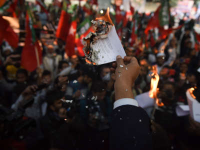 Demonstrators burn copies of Citizenship Amendment Bill during a protest in New Delhi, India, on December 10, 2019.