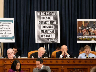 House republicans sit in front of sensationalistic signage